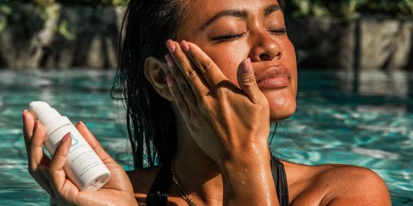 Eine Frau trägt das Bluphoria Gesichtselixier Lotusblüte & Hyaluron auf