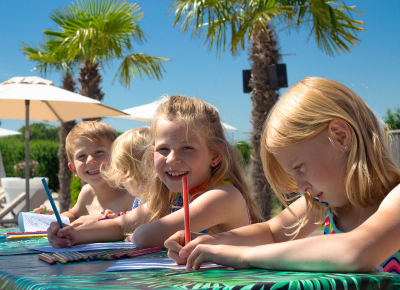 Vier Kinder basteln am Strand
