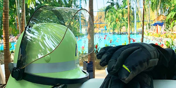 Ein Feuerwehrhelm und ein Feuerwehrhandschuh. Im Hintergrund l