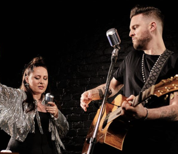 Ein Mann spielt Gitarre und eine Frau singt