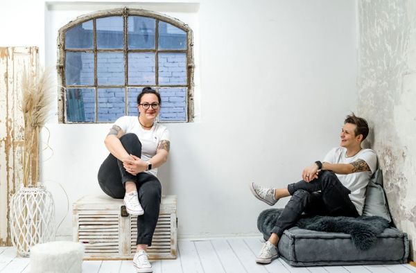 Zwei Frauen sitzen in einer gemütlichen Wohnzimmer-Atmosphäre