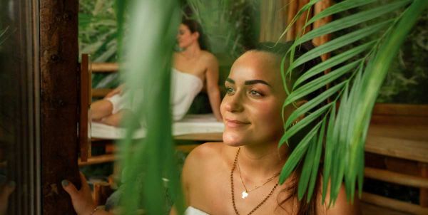 Eine Frau sitzt in der Tropensauna