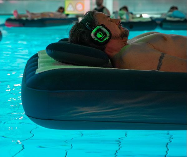 Mann liegt auf einer Luftmatratze mit Kopfhörern