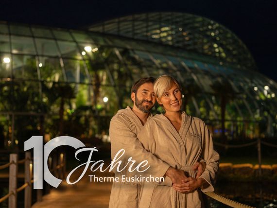 Mann und Frau umarmen sich in einer winterlichen Stimmung bei Nacht, Aufschrift "10 Jahre Therme Euskirchen"