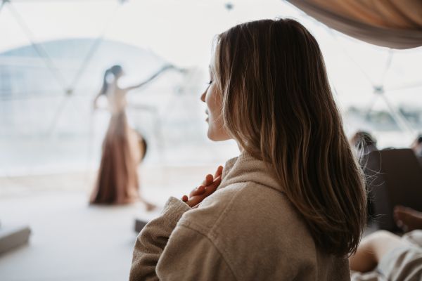 Eine Frau meditiert vor großer Glasfront im Mental Dome