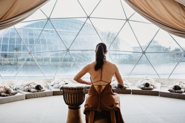 Eine Frau trommelt im Mental Dome vor einer Gruppe Menschen