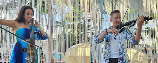 Zwei Menschen spielen im Dunkel Instrumente und leuchten