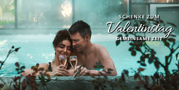 Frau und Mann mit Coaktails im Außenpool und Schrift mit "Schenke zum Valentinstag gemeinsame Zeit"