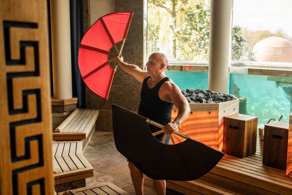 Ein Mann macht einen Aufguss in der Koi-Sauna