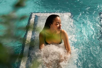 Eine Frau sitzt auf der Liege im Wasser