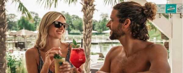 Ein Mann und eine Frau trinken Cocktails an der Beach Bar 
