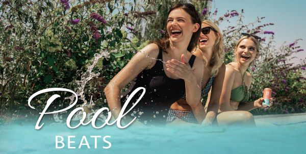 Drei Frauen sitzen mit Cocktails am Pool, Aufschrift "Pool Beats"