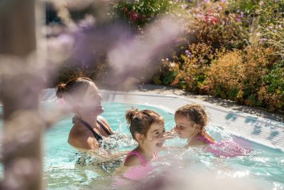 Eine Familie planscht im Außenpool