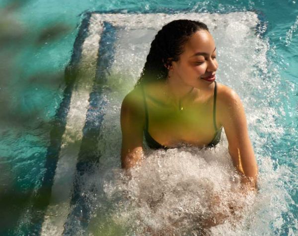 Ein Mann und eine Frau stehen  draußen unter den Wasserdüsen 