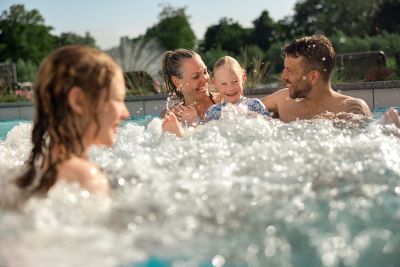 Eine Familie planscht im Außenpool
