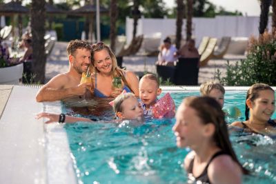 Familie entpannt zusammen im Pool. Mutter und Vater lachen