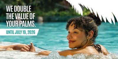 A woman in a swimming pool, with the caption ‘We’ll double the value of your palm trees until 19 July’