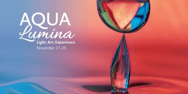 Event banner for AQUA Lumina (27–29 November) featuring the slogan ‘Light. Art. Experience.’. An artistic close-up of a glowing drop of water against a colour gradient ranging from blue-turquoise to red-orange. 