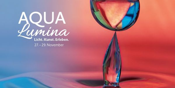 Event-Banner für AQUA Lumina (27.–29. November) mit dem Slogan „Licht. Kunst. Erleben.“. Kunstvolle Nahaufnahme eines leuchtenden Wassertropfens vor einem Farbverlauf von Blau-Türkis nach Rot-Orange.